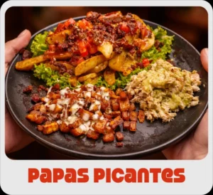 $15.000 | Porción de papas en cascos en salsa picante, acompañada de pollo desmechado, y porción de maduritos en salsas de la casa.